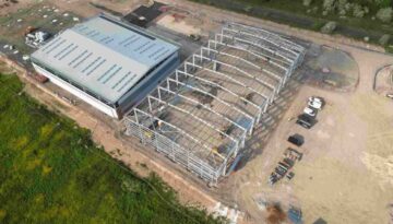 Aerial Shot of Industrial Building under Construction, Surrounded by Work yard and Grass Fields, Pioneer Design & Build