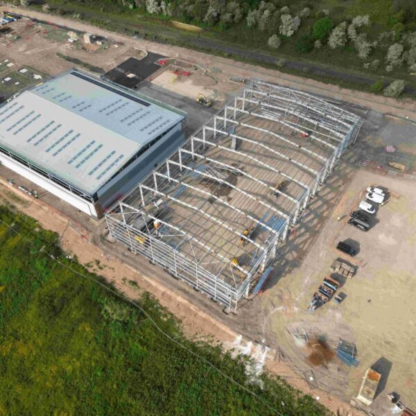 Aerial Shot of Industrial Building under Construction, Surrounded by Work yard and Grass Fields, Pioneer Design & Build